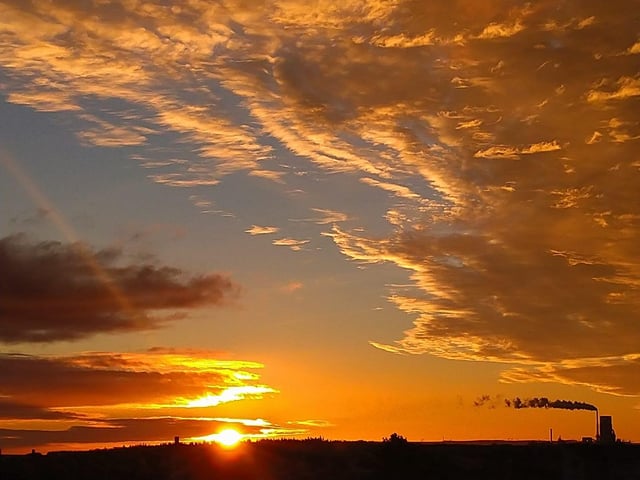 The sun peaks out as this north-east town awakes to orange skies and smoke billowing from an industrial chimney.