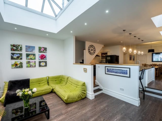 The superb informal family room is flooded with natural light from its large windows, patio doors and a lantern style cupola.