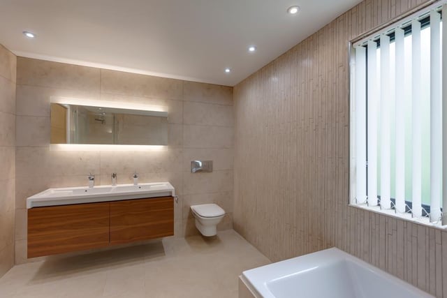 The family bathroom has a Roca suite in white, including a panelled bathtub - there's a separate shower enclosure with a rain head fitting.
