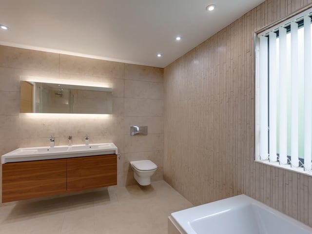 The family bathroom has a Roca suite in white, including a panelled bathtub - there's a separate shower enclosure with a rain head fitting.