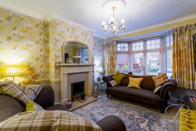 Part of the open-plan living and dining area is this living room, which is the perfect place to sit down and relax. It has a carpeted floor, a feature fireplace, central-heating radiator and a bay window to the front of the house.