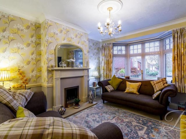Part of the open-plan living and dining area is this living room, which is the perfect place to sit down and relax. It has a carpeted floor, a feature fireplace, central-heating radiator and a bay window to the front of the house.