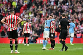 Manchester City's English midfielder Phil Foden (C) embraces Sheffield United's English-born Northern Irish midfielder Oliver Norwood: GLYN KIRK/AFP via Getty Images