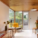 Original full-height sliding doors delineate the kitchen from the living area. The same timber ceiling visually connects these rooms and there is plenty of built-in cabinetry and storage space.