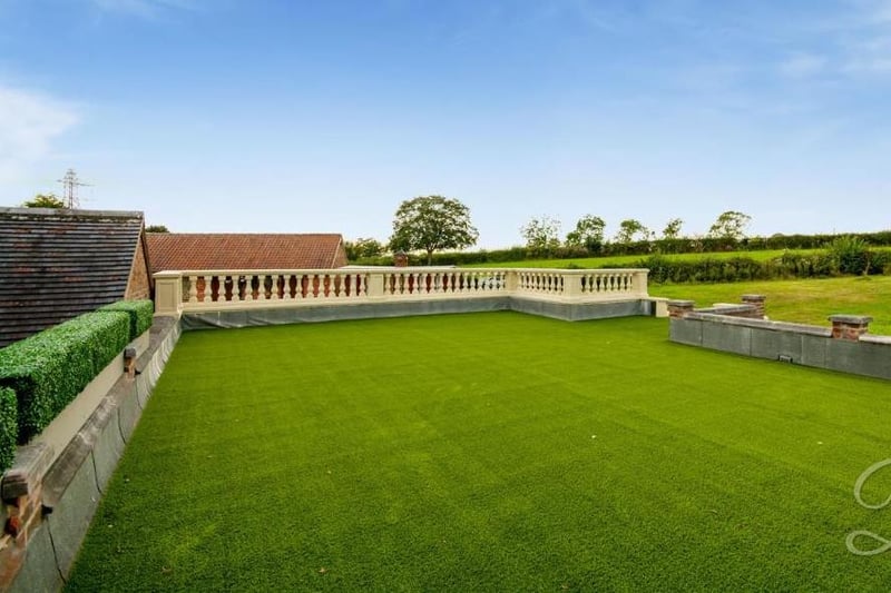 This shot of the artificial-grass terrace above the triple garage gives you an idea of the extensive land that surrounds the Lower Bagthorpe property. Green and clean.