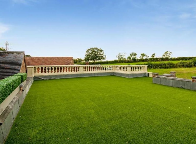 This shot of the artificial-grass terrace above the triple garage gives you an idea of the extensive land that surrounds the Lower Bagthorpe property. Green and clean.