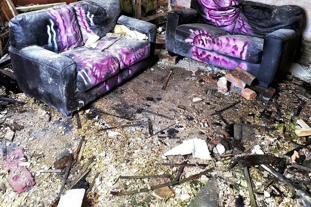 Two sofas seem out of place in the abandoned building.