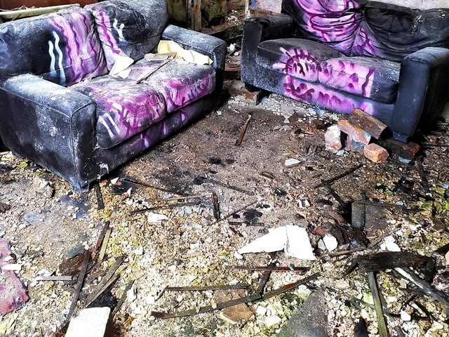 Two sofas seem out of place in the abandoned building.