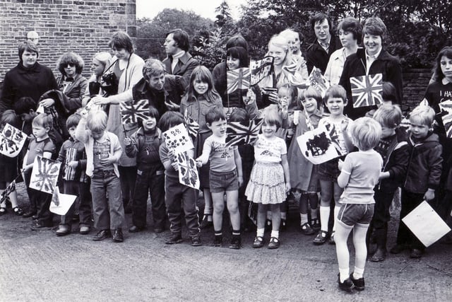 As children prepared a patriotic welcome for Princess Anne at Whirlow Hall Farm, one little lad seemed more interested in his companions than any Royal visitor who may appear - 19 July 1980
