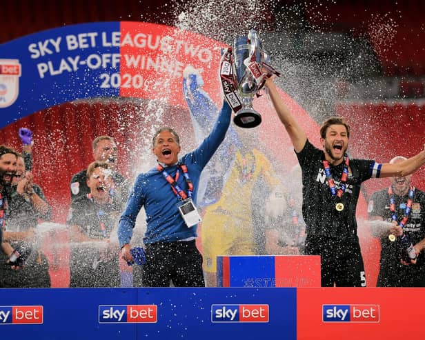 Northampton Town Manager Keith Curle lifts the trophy with captain Charlie Goode following the Sky Bet League 2 Play-Off Final match with Exeter City at Wembley Stadium, London on Monday 29th June 2020.