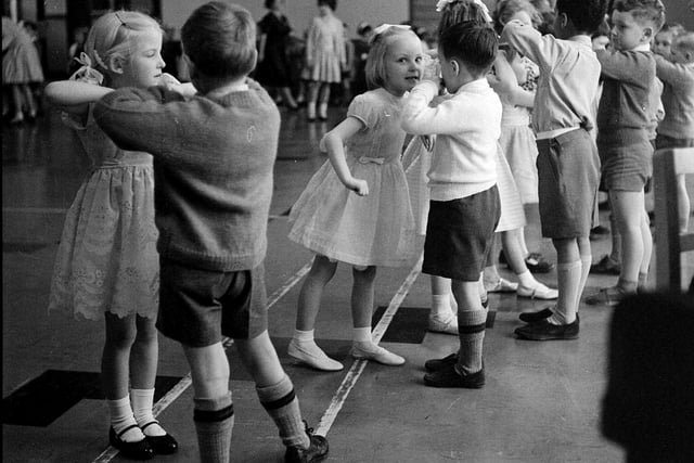 Children are pictured dancing at the Parsons Green School Infants Christmas Party in December 1962.