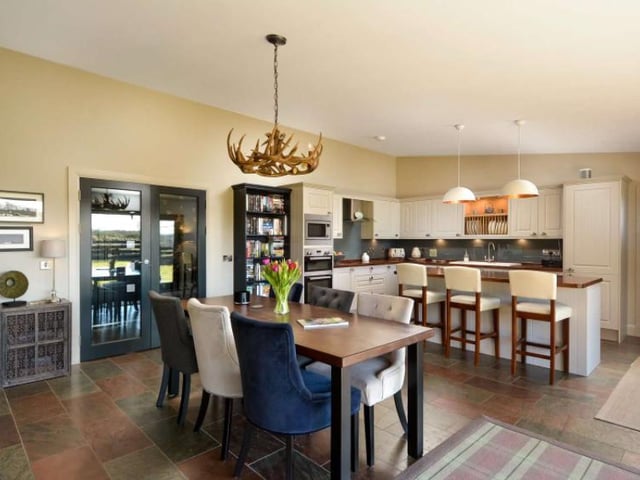 The dining leads into an open plan kitchen, although the two spots in the house are nicely separated by the kitchen island. The kitchen also boasts an Aga wood burning stove