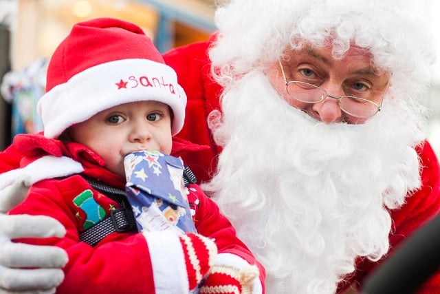 18 month old  Lily Hughes in her Santa suit with Father Christmas ready for Chesterfields Christmas Light Switch on, in 2012