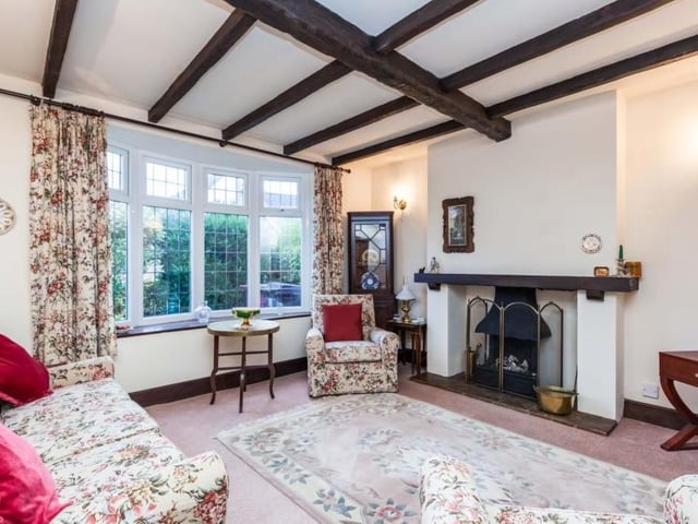 Through the front door and into the hallway, you will soon find this pleasant living room. Note the beams and the feature fireplace, not to mention the lovely window overlooking the front of the property.