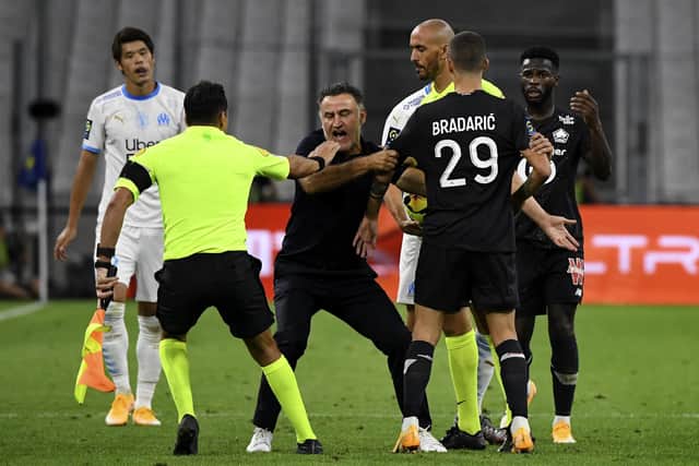 Lille's French coach Christophe Galtier (C) argues on the pitch with his player Lille's Croatian defender Domagoj Bradaric (R) during the French L1 football match between Marseille (OM) and Lille (LOSC), at the Velodrome stadium in Marseille. (Photo by NICOLAS TUCAT / AFP) (Photo by NICOLAS TUCAT/AFP via Getty Images)