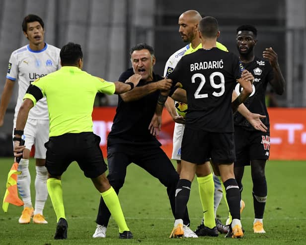 Lille's French coach Christophe Galtier (C) argues on the pitch with his player Lille's Croatian defender Domagoj Bradaric (R) during the French L1 football match between Marseille (OM) and Lille (LOSC), at the Velodrome stadium in Marseille. (Photo by NICOLAS TUCAT / AFP) (Photo by NICOLAS TUCAT/AFP via Getty Images)