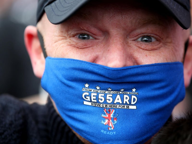 A Rangers fan wearing a celebratory face mask outside of the Ibrox Stadium after Rangers win the Scottish Premiership title.