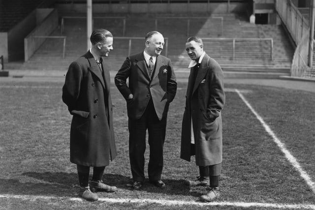 Arsenal manager Herbert Chapman (centre), chats with a key member of his team , Alex James (right), on the pitch at Wembley before the FA Cup final on 13th April 1932. It ended in a 1-0 win for Cardiff City.