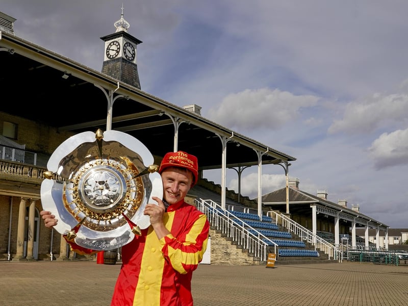 Tom Marquand celebrates with the trophy and cap after riding Galileo Chrome  victory in 2020, a race that was held behind closed doors due to the Covid pandemic.  