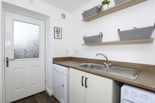 Just off the kitchen is this useful utility room. It has fitted base units with rolled edge worktops, a stainless steel sink with mixer taps and drainer, a built-in cupboard, space and plumbing for a washing machine and space for a tumble dryer. A door leads to the back garden.