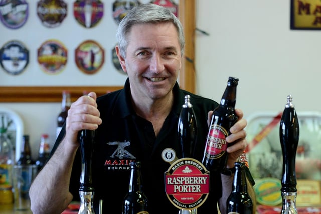 Mark Anderson at the Raspberry Porter pump with a bottle of the beer at Maxim Brewery. It's a scene from 2019.