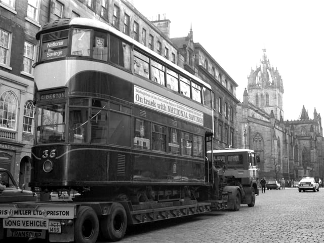 An old no 7 Edinburgh tram on its way to Blackpool travels up the Royal Mile on the back of a lorry in November 1983.