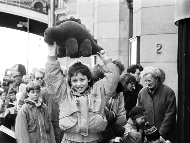 Iona Somerville wins a cuddly stegasaurus for being the 100,000th visitor to the Dinosaurs Alive! exhibition at the City Art Centre Edinburgh, April 1990.