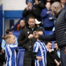Owls boss Darren Moore celebrates going top of the league with a fist bump with a young mascot. Pic Steve Ellis