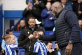 Owls boss Darren Moore celebrates going top of the league with a fist bump with a young mascot. Pic Steve Ellis