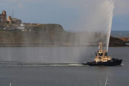The tug boat water display to herald the cruise liner's departure.