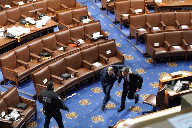 Members of Congress run as protesters try to enter the House Chamber