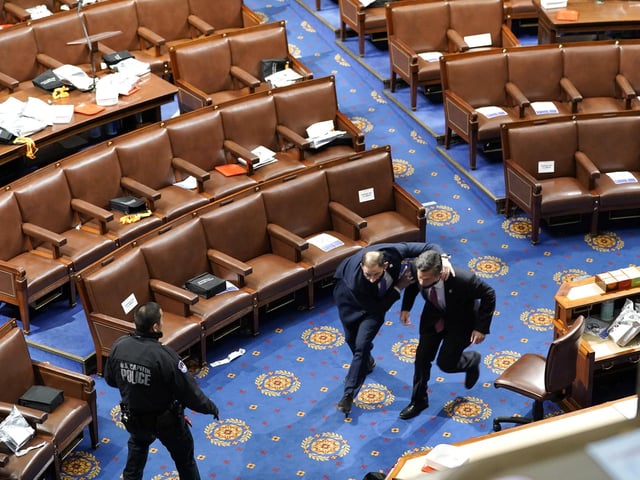Members of Congress run as protesters try to enter the House Chamber