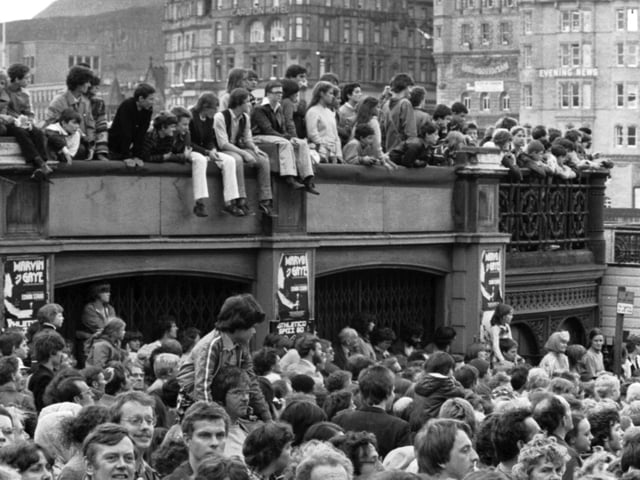 Crowds of people line Waverley Bridge to watch the Evening News Edinburgh Festival Cavalcade, August 1980.
