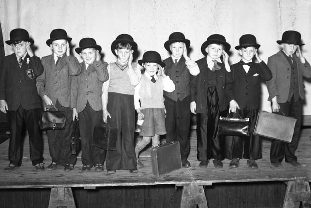 Suits, briefcases and bowler hats. These children were dressed up for a school play. Did you love to appear on the school stage?