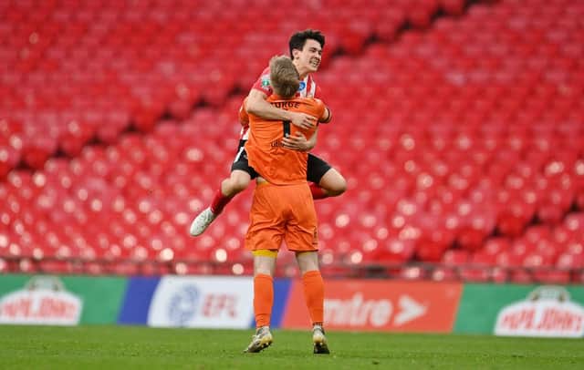 Lee Burge of Sunderland celebrates victory with team mate Luke O'Nien following the Papa John's Trophy Final match between Sunderland and Tranmere Rovers.