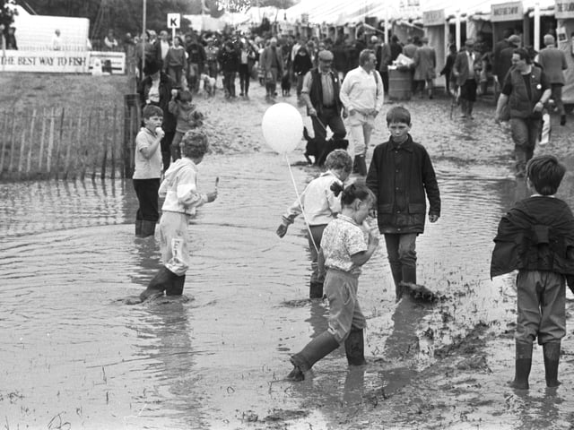 Children enjoy the puddles and mud at a rather wet Scottish Game Fair, held in Kelso, July 1988.