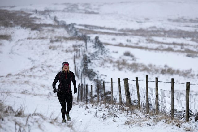 A lone jogger makes her way across Axe Edge Moor in the snow above Buxton Derbyshire. 
All Rights Reserved: F Stop Press Ltd.  
+44 (0)7765 242650 www.fstoppress.com www.rkpphotography.co.uk