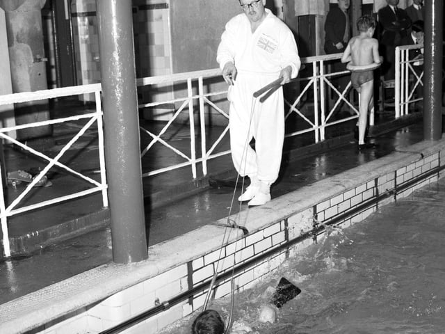 Instructor Norman Sarsfield teaching children to swim at Dalry Baths using a harness and flippers in January 1966.