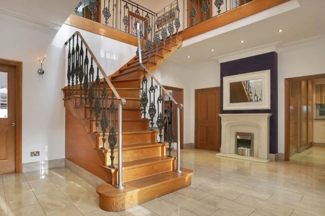 The property seeps grandeur from the outset, with a fabulous porch opening into this magnificent reception hallway. It includes a grand oak staircase of bespoke design, a porcelain tiled floor,  attractive feature-fireplace, ceiling spotlights and an under-stairs storage cupboard.