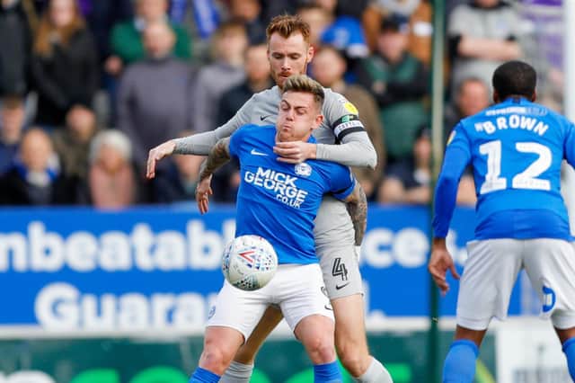 Portsmouth midfielder Tom Naylor (4) battles with Peterborough United midfielder Sammie Szmodics (9), on loan from Bristol City,  during the EFL Sky Bet League 1 match between Peterborough United and Portsmouth at London Road, Peterborough, England on 7 March 2020.