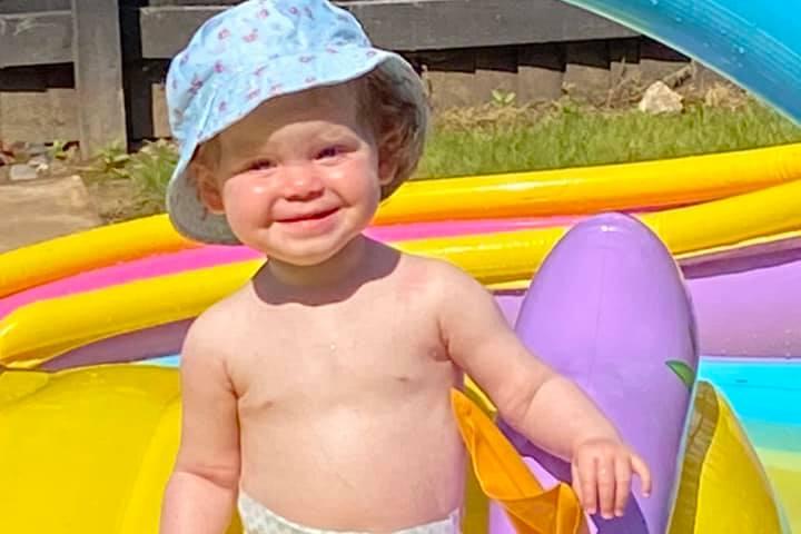 Remi-Lee enjoying the sun in a paddling pool.