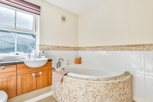 The family bathroom contains an elegant corner bath.