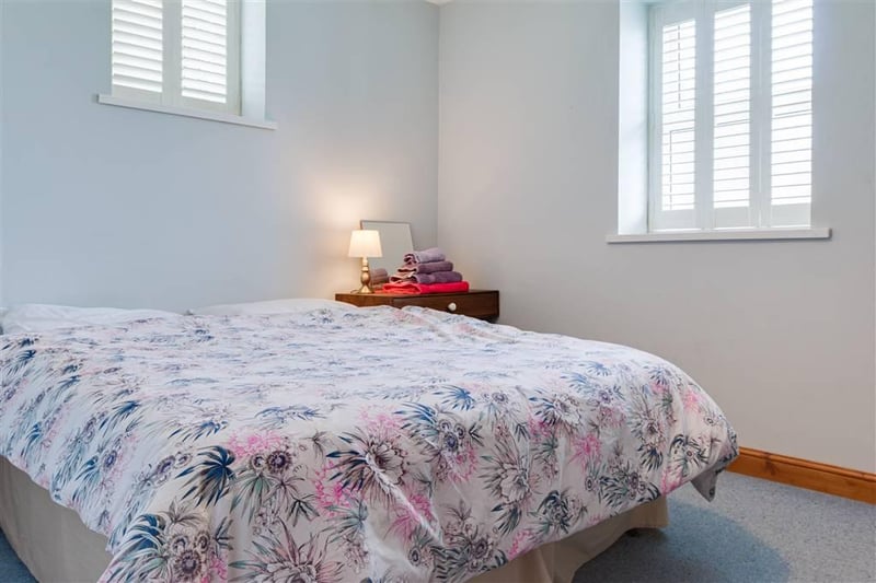 Bright and airy double room with custom shutters.