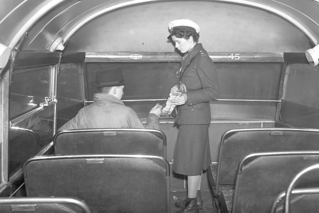 A bus conductress helps to keep Sunderland moving as she collects fares in 1940.