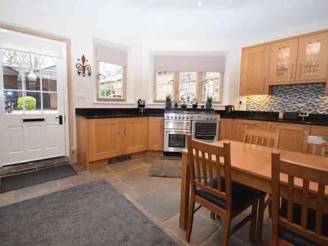 A final glance at the kitchen/diner, which also features an integrated, frost-free fridge freezer and dishwasher. Finishing touches include attractive flagstone flooring, two electric kickboard heaters and atmospheric downlighting. Two large windows fill the room with natural light, while a door leads to the courtyard.