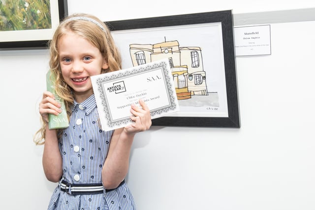 Chloe Daykin recently won second place in the Junior Artist of the Year competition, in the prestigious SAA’s (Supporting All Artists) 2021 Artists of the Year competition.The Abbey Primary School pupil was awarded for a painting of Mansfield Town Hall and received a Supporting All Artists Award for a picture of a packet of Skips. She recently met with Mansfield MP Ben Bradley at the Nottinghamshire Spectrum Wasp charity who congratulated her on her win. Here she is pictured receiving her awards.