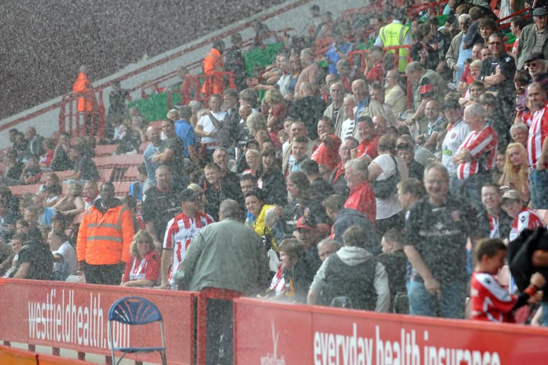 Blades fans get a soaking at half time as the pitch sprinkler system, caught by a gust of wind, sends water into the stand