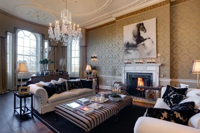 The living room is grand in size and style, with large windows, a chandelier and a double height ceiling. The  property also has a large study, a morning room, and a library.