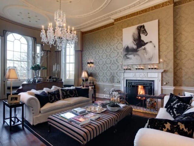 The living room is grand in size and style, with large windows, a chandelier and a double height ceiling. The  property also has a large study, a morning room, and a library.