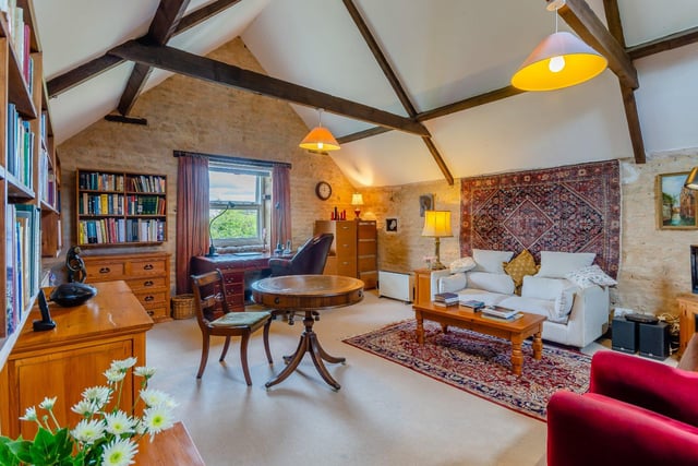 Currently used as a library, this grand room features wooden beams overhead, exposed stone walls and enjoys views over the grounds.